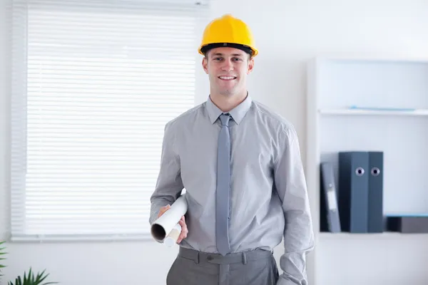 Architect wearing helm and carrying plans — Stock Photo, Image