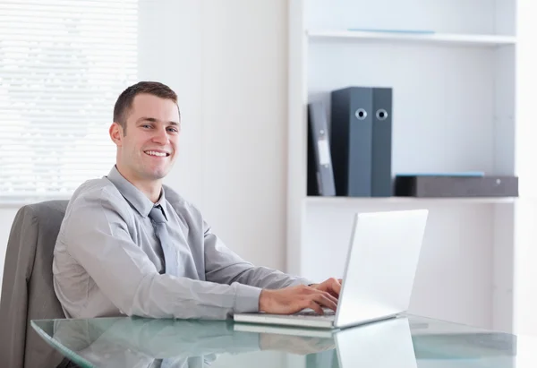 Tevreden zakenman die op zijn laptop werkt — Stockfoto