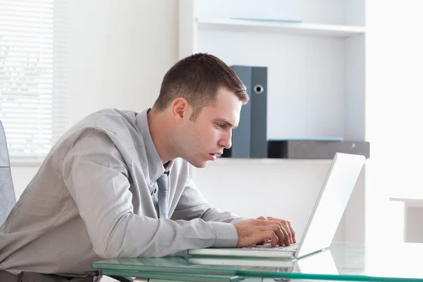 Бизнесмен внимательно изучает свой ноутбук — стоковое фото