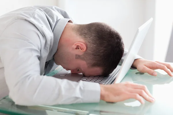 Close up de empresário sobrecarregado tirando uma soneca em seu laptop — Fotografia de Stock