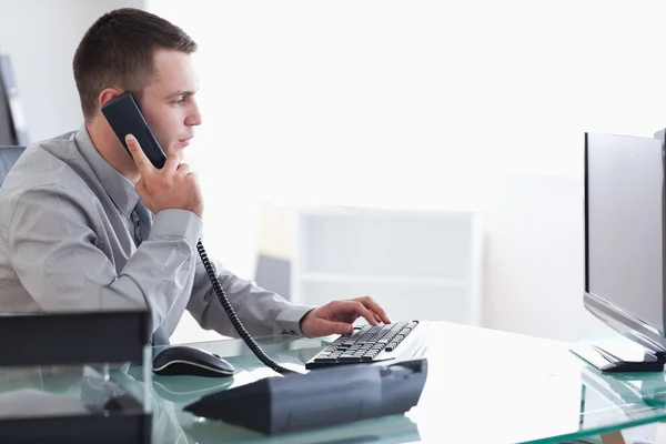 Affärsman att skriva medan på telefonen — Stockfoto
