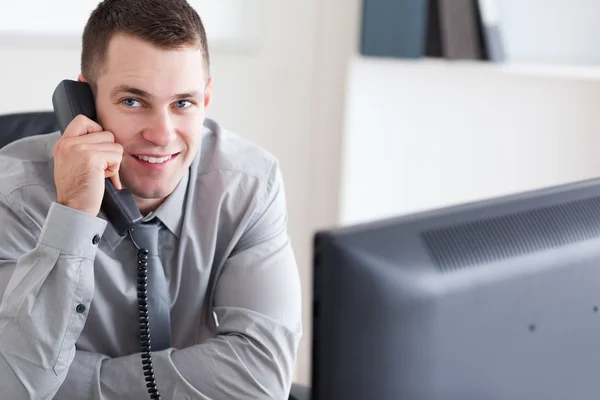 Улыбающийся бизнесмен слушает телефон — стоковое фото