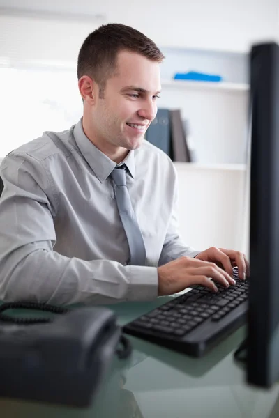 Χαμογελώντας επιχειρηματίας που εργάζεται στον υπολογιστή του — Φωτογραφία Αρχείου