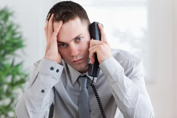 Uomo d'affari che riceve cattive notizie al telefono — Foto Stock