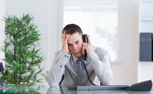 Empresário recebendo notícias decepcionantes no telefone — Fotografia de Stock