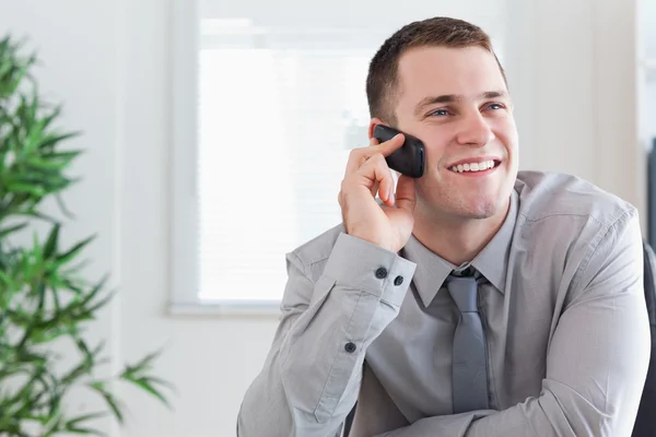 Un homme d'affaires reçoit un appel agréable sur son téléphone portable — Photo
