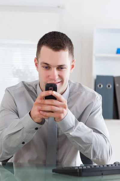 Businessman getting a pleasant text message — Stock Photo, Image