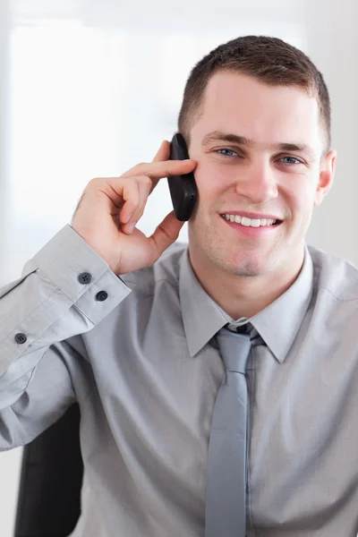 Nahaufnahme eines lächelnden Geschäftsmannes, der gute Nachrichten am Telefon bekommt — Stockfoto