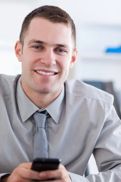 Närbild på leende affärsman med mobiltelefon i handen — Stockfoto