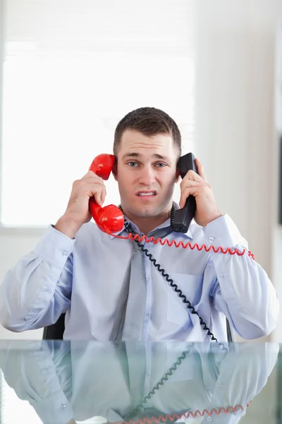 Businessman getting overextended by the telephone — Stock Photo, Image