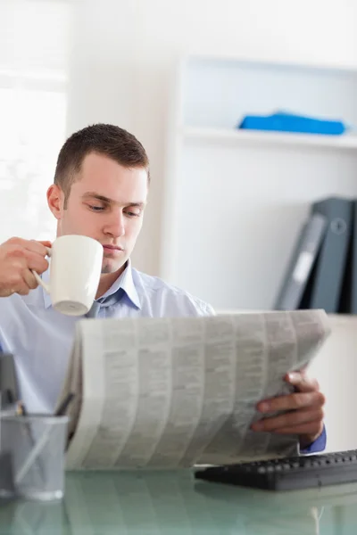 Empresário lendo o jornal e tomando um café — Fotografia de Stock