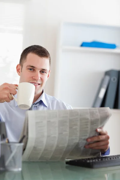 ビジネスマン、新聞を読んだり、コーヒーを飲んでの笑みを浮かべてください。 — ストック写真