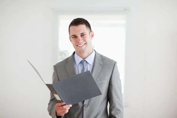 Hombre de negocios sonriente con carpeta abierta — Foto de Stock