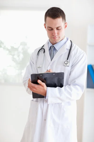 Doctor having a look at his notes — Stock Photo, Image