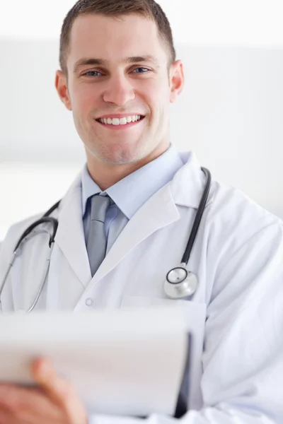 Bliska uśmiechający się lekarza z jego notatek — Zdjęcie stockowe