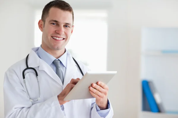 Uśmiechający się lekarz z jego tabletki — Zdjęcie stockowe