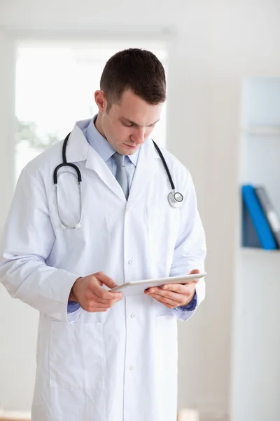 Doctor having a look at his tablet — Stock Photo, Image