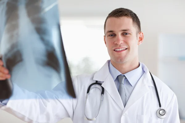 Lachende jonge arts kijken naar x-ray — Stockfoto