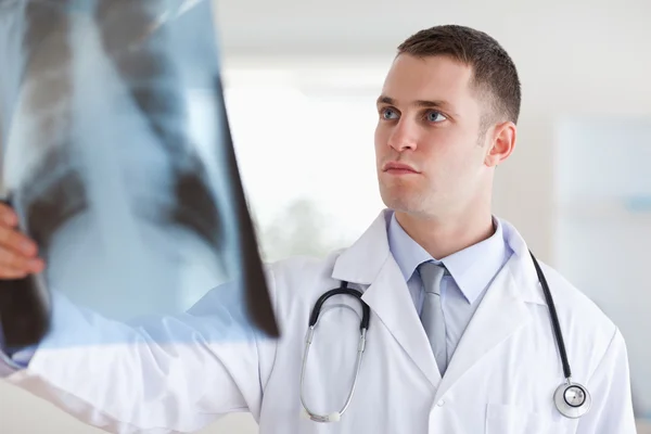 Лікар серйозно дивиться на рентгенівський знімок — стокове фото