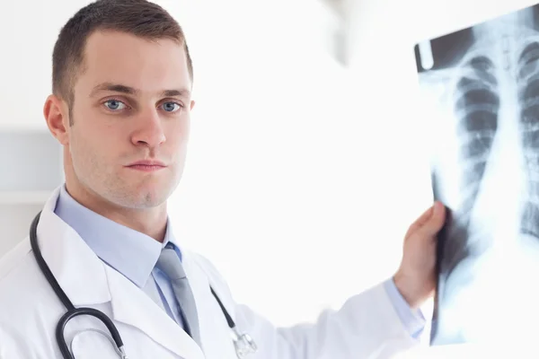 Serious looking doctor showing x-ray to patient — Stock Photo, Image