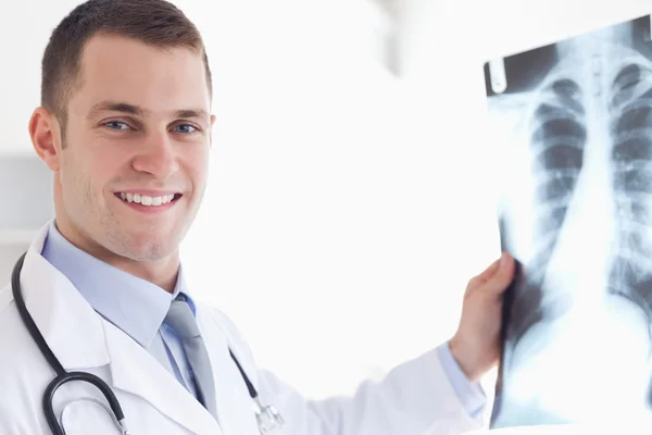 Médico sorridente mostrando raio-X para o paciente — Fotografia de Stock