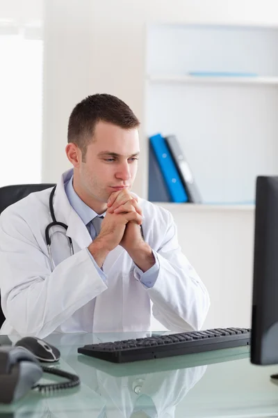 Arzt blickt auf Computerbildschirm — Stockfoto