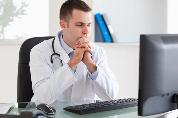 Pensando medico guardando il suo schermo — Foto Stock