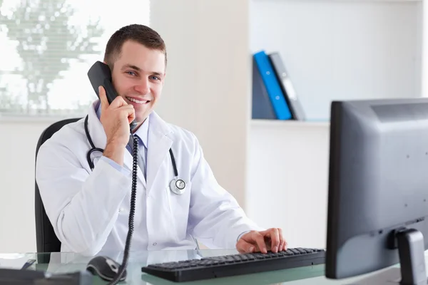 Leende läkare på telefon — Stockfoto