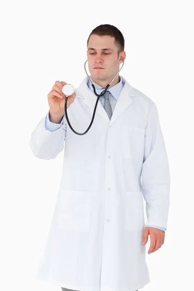Arzt schaut während der Anwendung auf Stethoskop — Stockfoto
