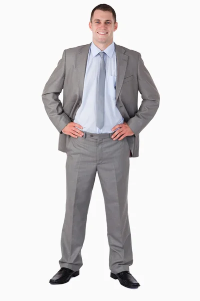 Smiling businessman with arms akimbo — Stock Photo, Image