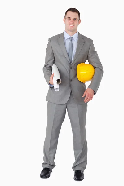 Smiling architect with helm and plans — Stock Photo, Image