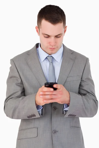 Nahaufnahme eines jungen Geschäftsmannes, der SMS schreibt — Stockfoto
