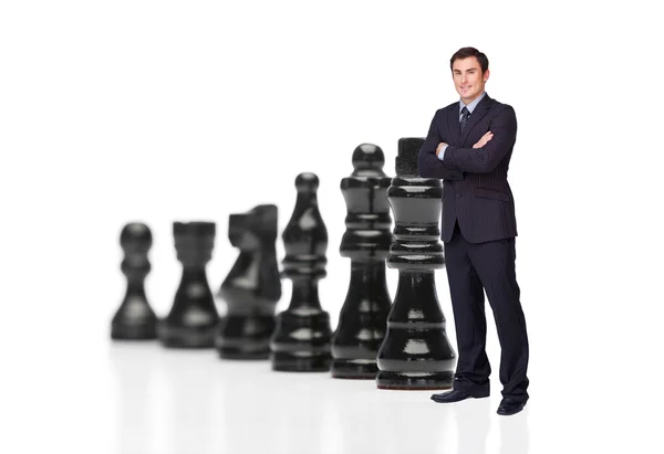 Empresário na frente de peças de xadrez preto — Fotografia de Stock