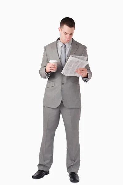 Ritratto di un uomo d'affari che legge le notizie mentre tiene in mano una tazza o — Foto Stock