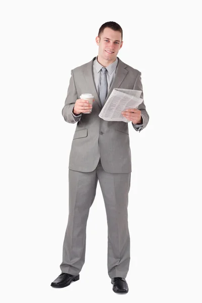 Ritratto di un uomo d'affari che legge le notizie mentre tiene in mano una tazza o — Foto Stock