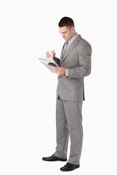 Retrato de un hombre de negocios sosteniendo una taza de té mientras lee el —  Fotos de Stock