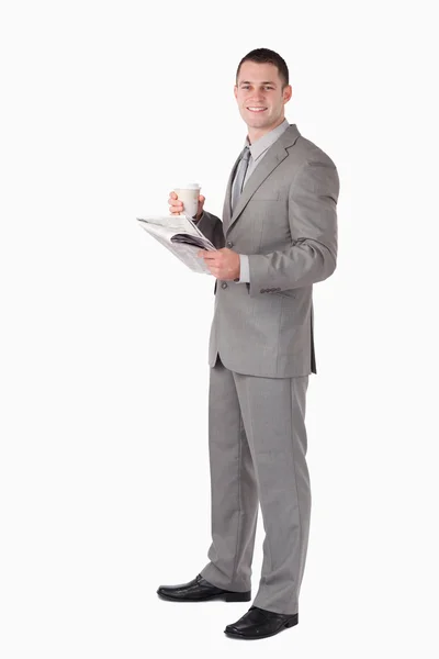 Retrato de un hombre de negocios sosteniendo una taza de café mientras lee —  Fotos de Stock