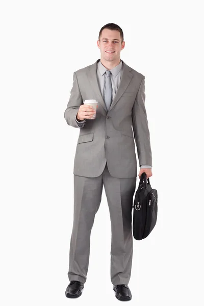 Portrait of a businessman holding a cup of coffee and a computer — Stock Photo, Image