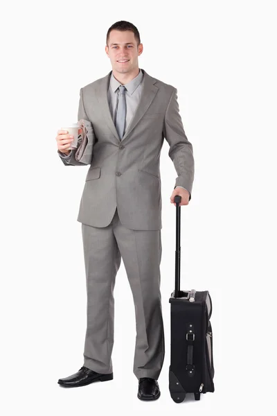 Porträtt av en affärsman som innehar en kopp kaffe och en resväska — Stockfoto