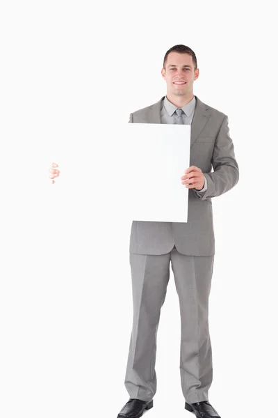 Porträt eines lächelnden Geschäftsmannes, der eine leere Tafel zeigt — Stockfoto