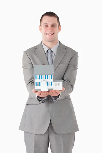 Portrait of a businessman showing a miniature house — Stock Photo, Image