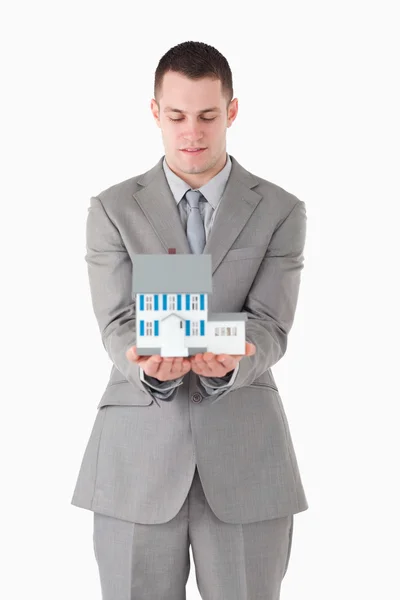 Portrait of a businessman looking at a miniature house — Stock Photo, Image