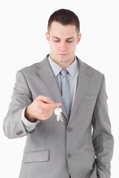 Retrato de um jovem empresário olhando para um conjunto de chaves — Fotografia de Stock