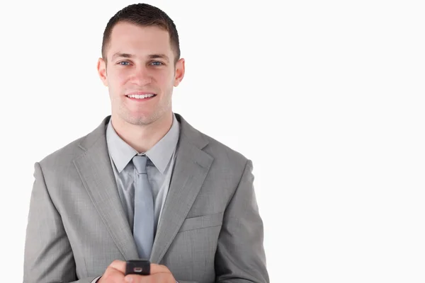 Podnikatel drží jeho mobil — Stock fotografie