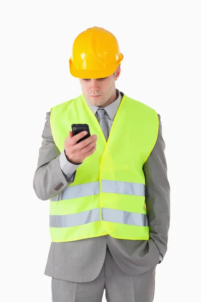 Portret młodego konstruktora, patrząc na swój telefon komórkowy — Zdjęcie stockowe