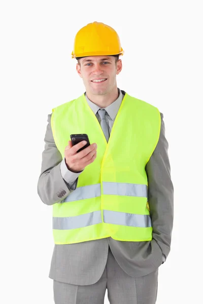 Porträtt av en ung byggare som håller hans mobiltelefon — Stockfoto