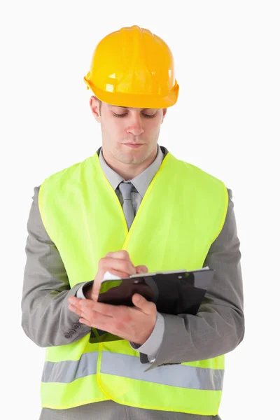 Retrato de um jovem construtor tomando notas — Fotografia de Stock