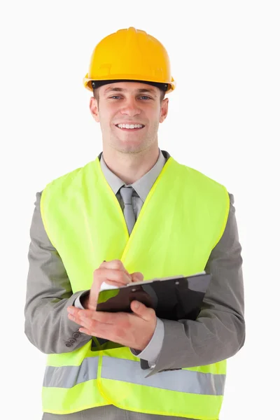 Porträt eines lächelnden Bauarbeiters, der Notizen macht — Stockfoto