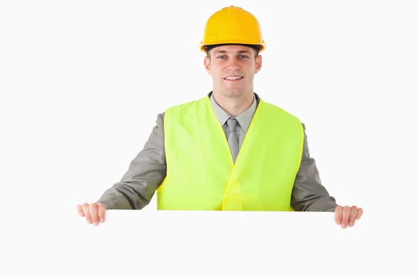 Construtor segurando um painel em branco — Fotografia de Stock