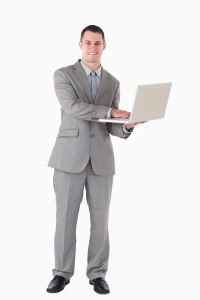 Retrato de um jovem empresário segurando um laptop — Fotografia de Stock